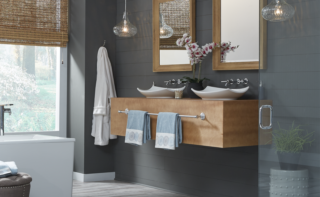 floating light wood vanity with white sinks and silver hardware in grey bathroom with neutral waterproof flooring