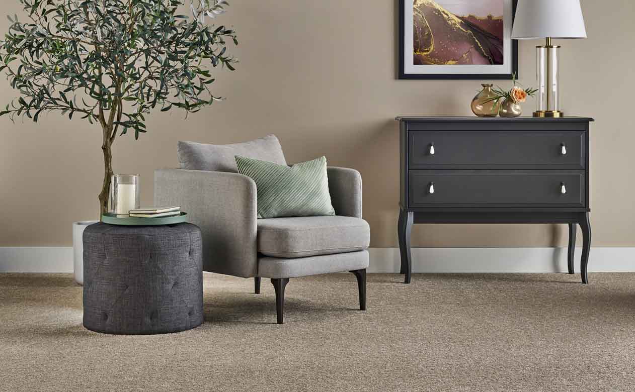 Living room with brown chair, ottoman, and dresser with beige carpet in Cypress, TX